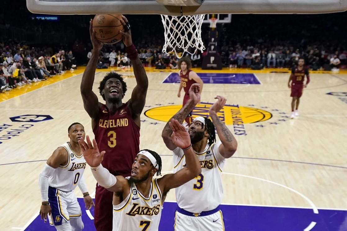 Caris LeVert de los Cavaliers de Cleveland realiza un tiro ante la defensa de Troy Brown y  Anthony Davis, de Los Lakers de Los Ángeles. Foto Ap