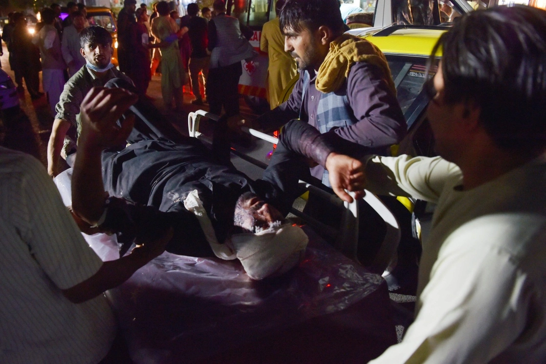 Personal médico traslada a un hombre herido en una camilla para recibir tratamiento después de dos explosiones registradas frente al aeropuerto de Kabul, Afganistán, el 26 de agosto de 2021. Foto Afp