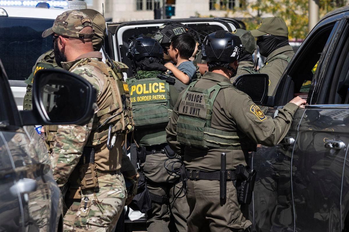 Un agente federal carga a un niño mientras realizan un operativo de detención en Chicago. 