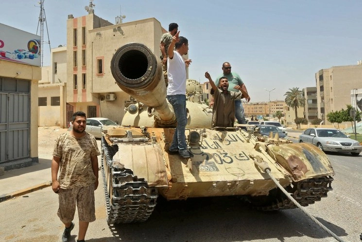 Combatientes leales al Gobierno de Acuerdo Nacional (GNA) de Libia, reconocido por la ONU, se paran sobre un tanque en la ciudad de Tarhouna, a unos 65 kilómetros al sureste de la capital, Trípoli. Foto Afp
