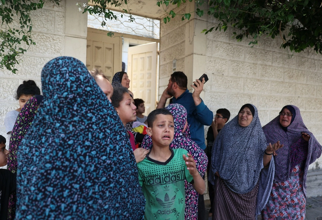 Mujeres y niños palestinos evacúan sus casas en busca de un lugar de refugio durante un bombardeo israelí en Gaza, el 20 de mayo de 2021. Foto Afp