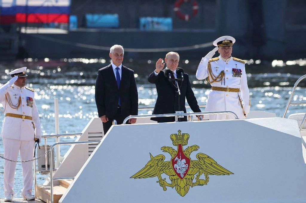 El presidente ruso Vladimir Putin, el ministro de Defensa ruso, Andrei Belousov, y el comandante en jefe de la Armada rusa, el almirante Alexander Moiseyev, asisten a la ceremonia naval que conmemora el Día de la Armada Rusa en San Petersburgo, el 28 de julio de 2024. Foto Afp