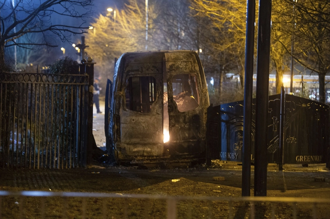 Una camioneta de la policía quemada después de una manifestación frente al Hotel Suites en Knowsley, Merseyside, donde la gente protestaba contra los solicitantes de asilo alojados en el hotel, en Knowsley, Inglaterra. Foto Ap