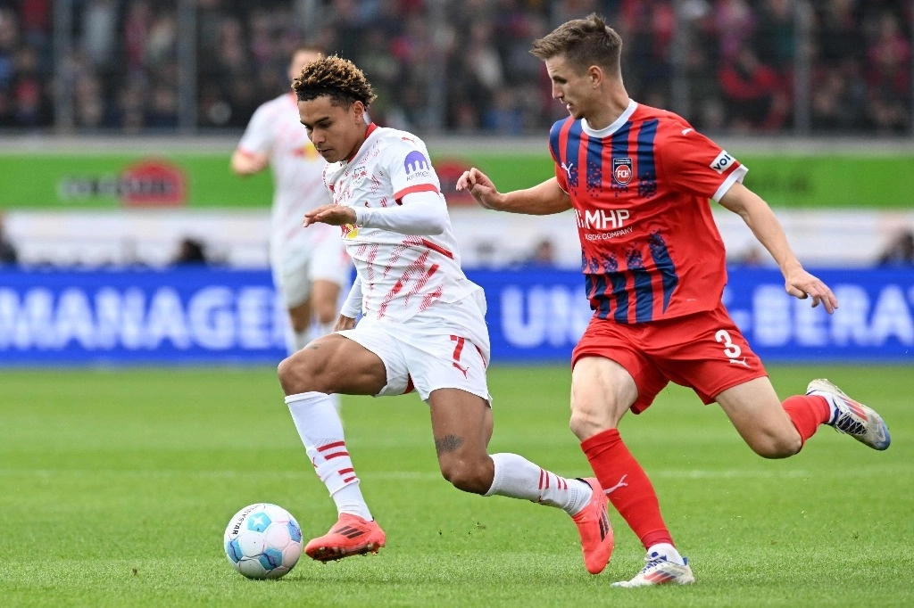 Antonio Nusa del Leipzig controla el balón frente a la marca de Jan Schoeppner del Heidenheim, en el juego de la fecha seis de Bundesliga. Foto Afp