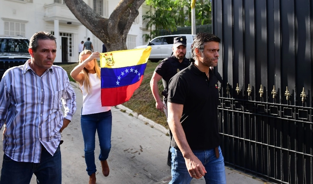 El opositor venezolano Leopoldo López seguido de su esposa Lilian Tintori con una bandera venezolana, salen de la embajada española en Caracas. Foto Afp 