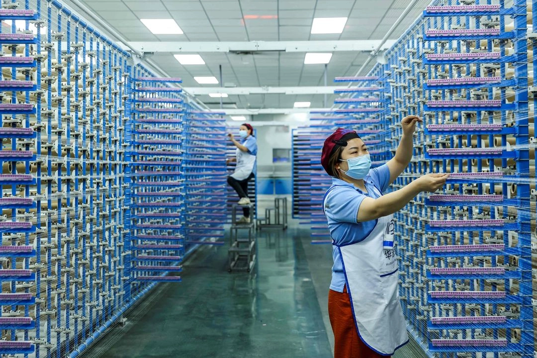 Empleados trabajan en una fábrica que produce productos de fibra de vidrio en Jiujiang, en la provincia oriental china de Jiangxi, el 13 de mayo de 2025. Foto 