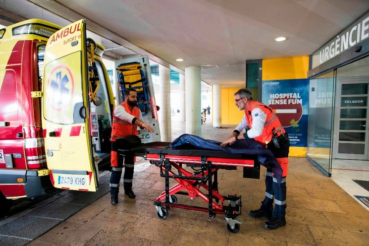 Dos hombres preparan una ambulancia frente al Hospital Universitario Son Espases en Palma de Mallorca, donde un hombre británico ha sido diagnosticado con coronavirus, el 9 de febrero de 2020. Foto Afp