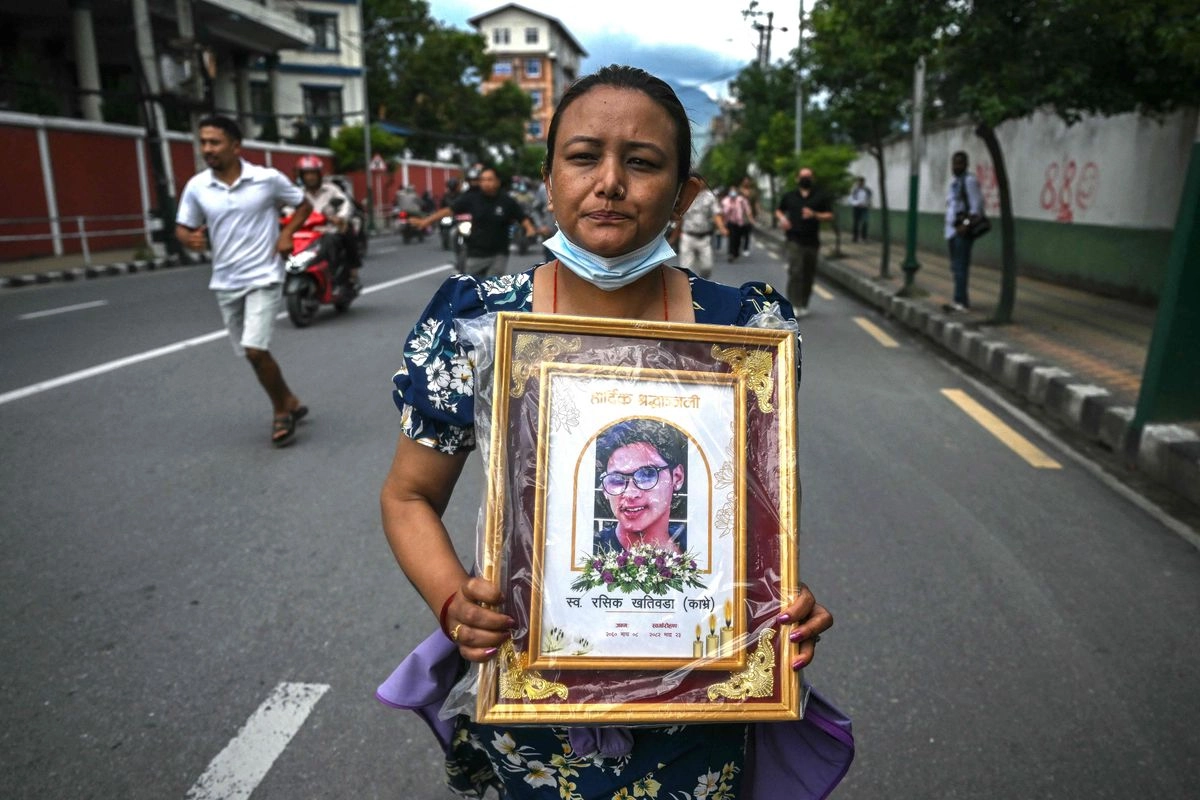 Una mujer sostiene un retrato de su familiar, fallecido durante enfrentamientos con personal de seguridad, durante una marcha de protesta en Katmandú, Nepal, el 13 de septiembre de 2025. 