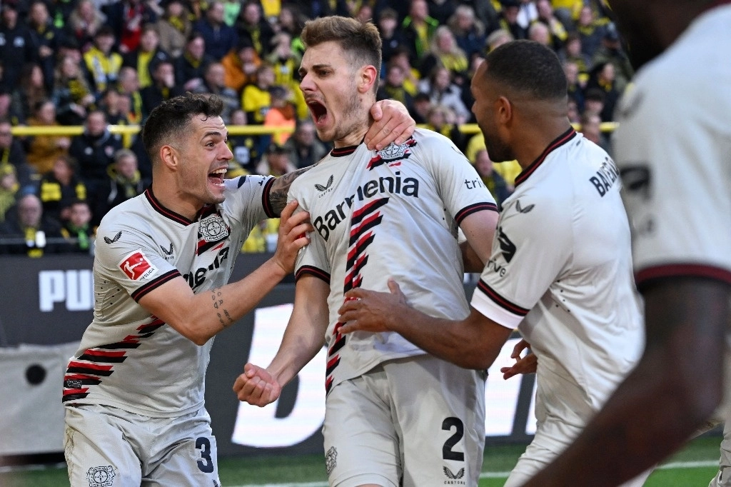 Josip Stanisic (centro) del Bayer Leverkusen empató de último minuto el duelo ante Borussia Dortmund. Foto Afp 