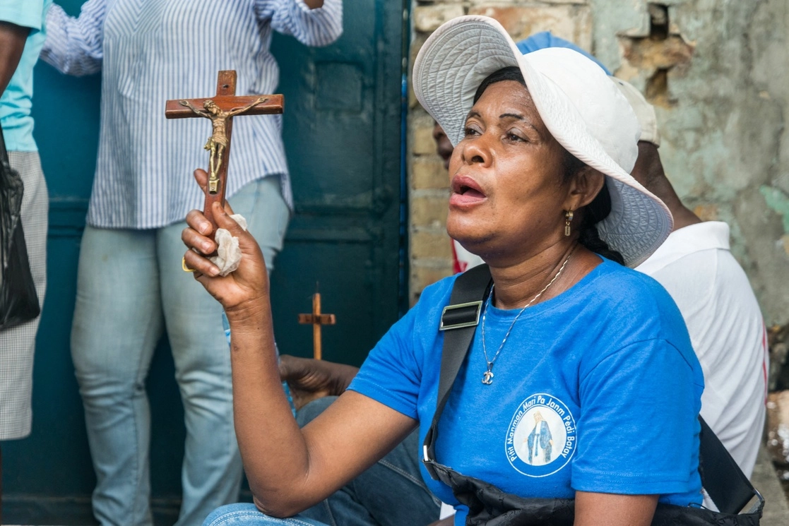 Una mujer en Puerto Príncipe, Haití sostiene una cruz durante la procesión de Semana Santa. Foto Afp / Archivo