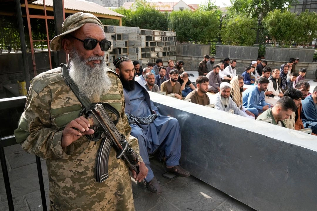 Musulmanes afganos realizan la oración del Eid al-Adha mientras un combatiente talibán hace guardia en la mezquita Shah-Do Shamshira en Kabul, Afganistán, el 7 de junio de 2025. Foto 