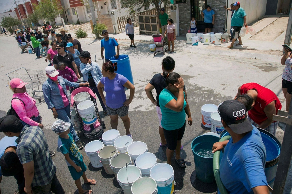 Personas hacen fila para recibir agua de una pipa, en Monterrey, Nuevo León, ante el racionamiento y escasez de este líquido en Nuevo León. Foto Afp