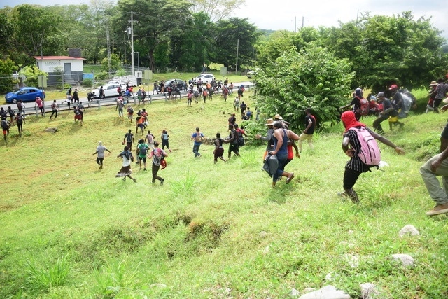 Migrantes de una caravana con rumbo a Estados Unidos corren para evitar ser detenidos por la Guardia Nacional en Mapastepec, Chiapas. Foto Xinhua / Archivo