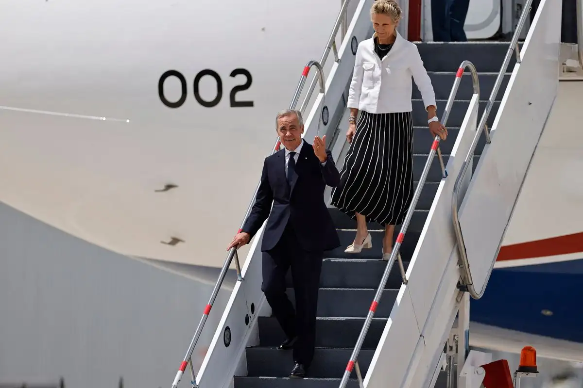 Mark Carney, primer ministro de Canadá, y su esposa Diana Fox Carney, descienden del avión a su arribo a México, en el AIFA, estado de México. 