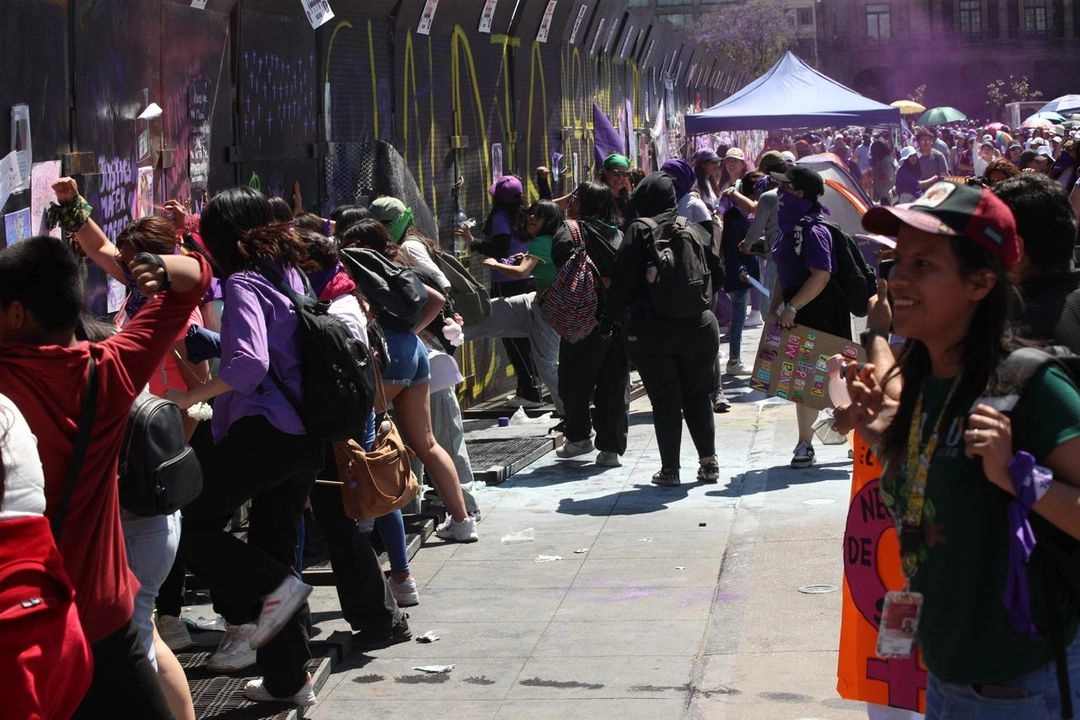 Participantes en la marcha por el Día Internacional de la Mujer arremeten contra las vallas que cubren el Palacio Nacional, en el Zócalo de la Ciudad de México, el 8 de marzo de 2025. Foto 