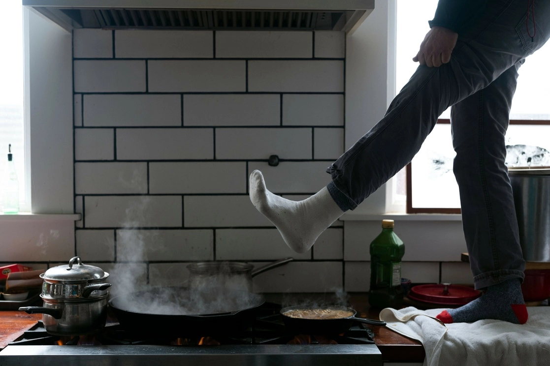 Un residente de Austin, Texas, se para en la encimera de la cocina para calentarse los pies sobre la estufa de gas después que se cortó la electricidad para miles de familias por una tormenta de nieve azotó el área el domingo pasado. Foto Ap