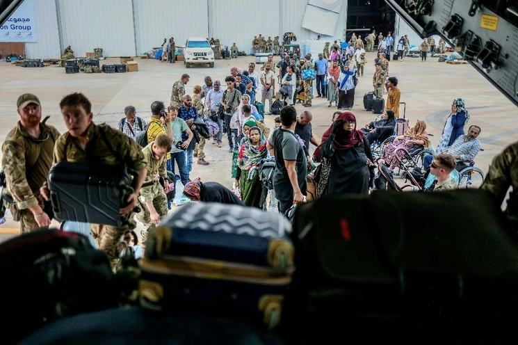 Personas son evacuadas a un avión de la RAF en la base aérea de Wadi Seidna, en Sudán. Foto Ap