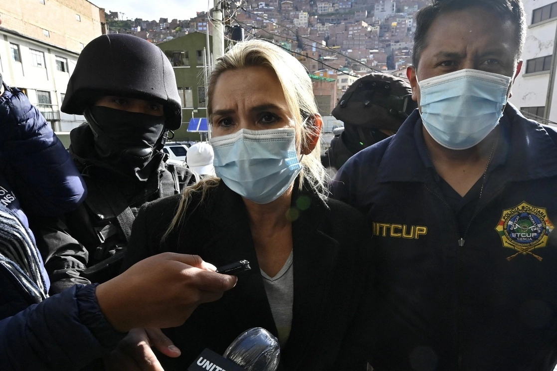 La ex presidenta interina de Bolivia, Jeanine Áñez, es escoltada por miembros de la policía de la Fuerza Especial contra el Crimen (FELCC) después de ser arrestada en La Paz, el 13 de marzo de 2021. Foto Afp 
