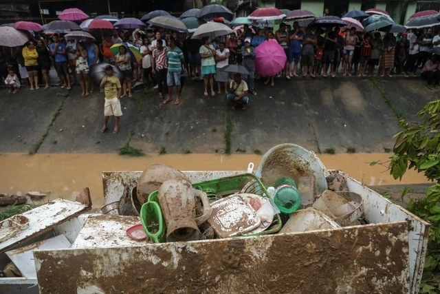 Residentes de Recife observan cómo rescatistas buscan sus pertenencias entre el lodo, tras las torrenciales lluvias. Foto Afp