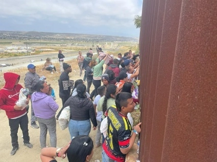 Migrantes aguardan en el muro fronterizo entre México y EU. Foto Mireya Cuéllar / archivo
