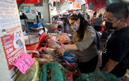 Las piezas para un caldo o un vuelve a la vida son examinadas por quienes acuden a comprar. Foto María Luisa Severiano