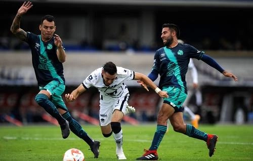 El auriazul Manuel Mayorga intenta pasar entre la marcación de los poblanos durante el partido en Ciudad Universitaria.Foto Ap