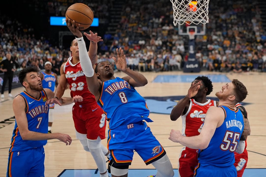El delantero del Oklahoma City Thunder, Jalen Williams (8), lanza el balón más allá del escolta de los Memphis Grizzlies, Desmond Bane (22), durante la primera mitad del cuarto juego de una serie de playoffs de primera ronda de baloncesto de la NBA 
