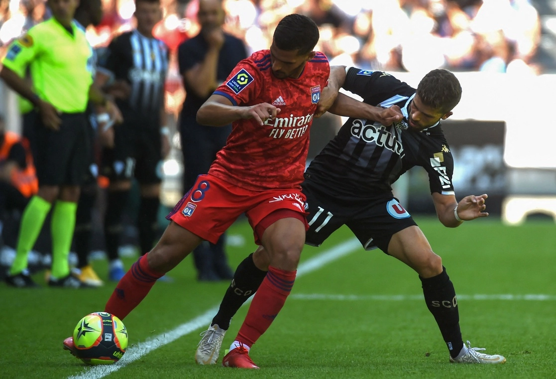 Houssem Aouar del Lyon (izquierda) y Jimmy Cabot del Angers disputan el esférico en la cancha del estadio Raymond Kopa, en la jornada dos de la Ligue 1. Foto Afp