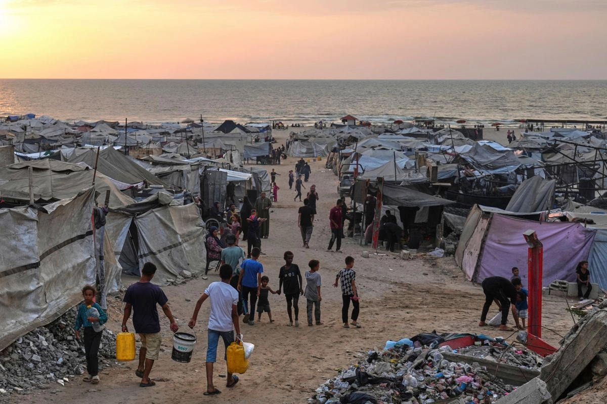 Tiendas de campaña que albergan a palestinos desplazados abarrotan la playa de la ciudad de Gaza, mientras el sol se pone sobre el mar Mediterráneo, el domingo 10 de agosto de 2025. Foto
