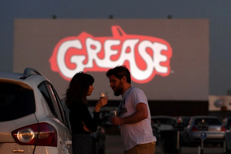 Una pareja espera a la proyección de la cinta “Vaselina”, durante la reapertura del autocinema Madrid Race Drive, mientras España alivia las medidas del confinamiento adoptadas como medida de mitigación de la propagación del Covid-19, el 27 de mayo de 2020. Foto Afp 
