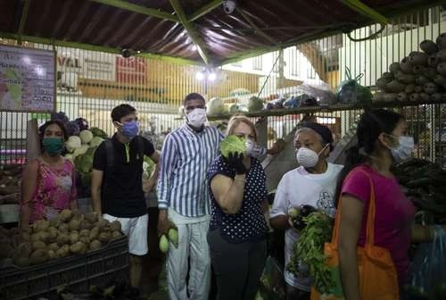 Provistos de mascarillas, venezolanos acuden al mercado en Caracas, pero sin guardar la distancia recomendada por los especialistas para evitar el contagio de Covid-19. Foto Ap