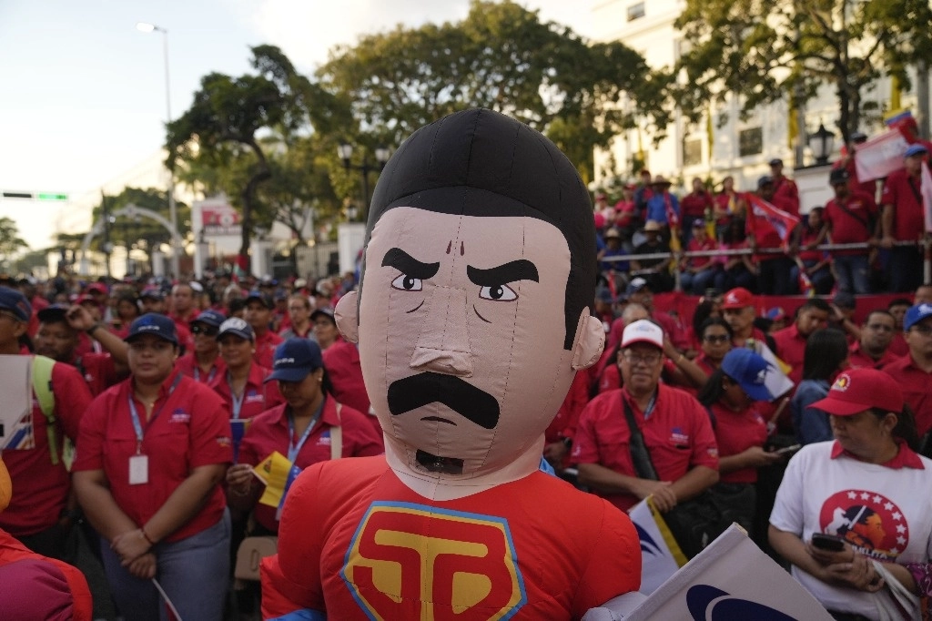Un simpatizante del gobierno venezolano con un traje de Superbigote –personaje que representa al presidente Nicolás Maduro–, ayer en una manifestación afuera del Palacio de Miraflores, en Caracas, a horas de la toma de posesión del chavista para un tercer mandato presidencial. Foto Ap 



