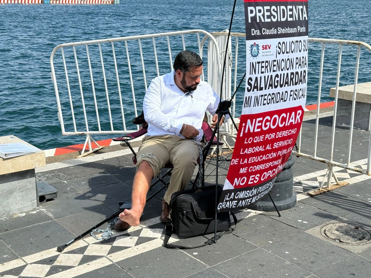 El maestro Juan Miguel Ríos Andrade se encadenó en el malecón de Veracruz, donde esta tarde se conmemorará el 204 aniversario de la creación de la Semar y 201 años de la Promulgación de la Primera Constitución de 1824, evento al que acudirá la presidenta Claudia Sheinbaum. Foto 