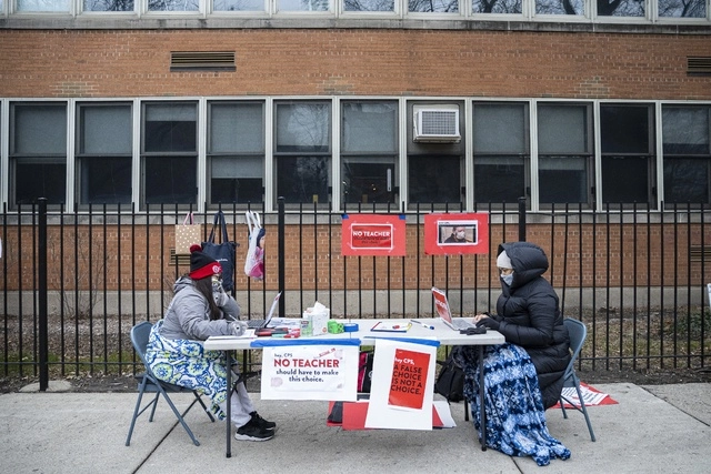 Maestros en Chicago dan clases virtuales afuera de un colegio para manifestarse contra la orden de regresar a las aulas sin ser vacunados. Foto Ap