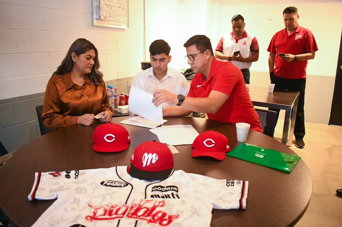 El joven de 16 años originario de Guasave al suscribir su contrato con Cincinnati. Foto cortesía de Diablos Rojos
