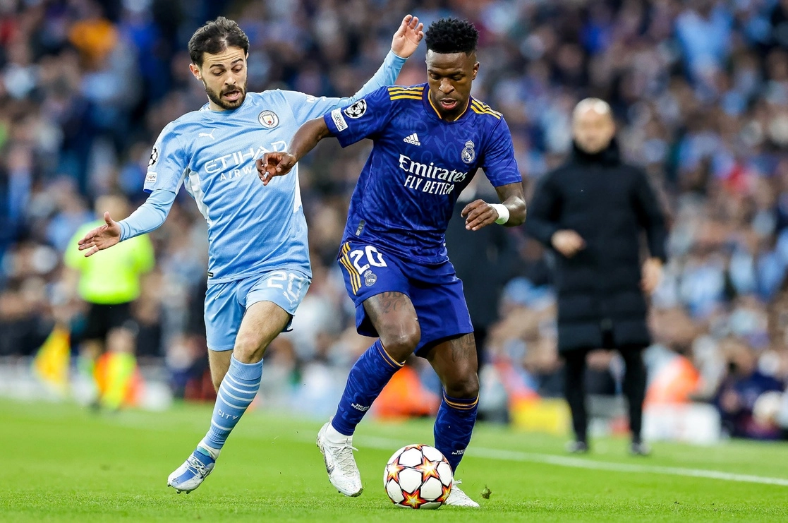 Bernardo Silva, del City (izq.), disputa el balón con Vinícius Júnior, del Madrid. El conjunto Sky Blue ganó 4-3. Foto Xinhua.