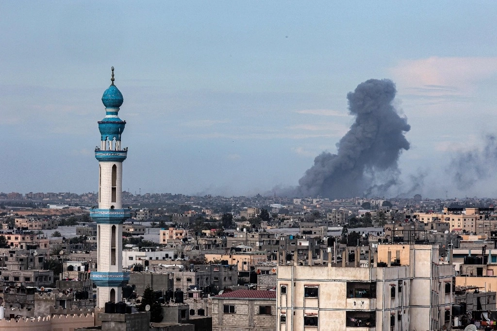 Fotografía tomada desde Rafá muestra humo ondeando sobre Khan Yunis en la distancia, después del bombardeo israelí en el sur de la franja de Gaza, el 14 de febrero de 2024. Foto Afp