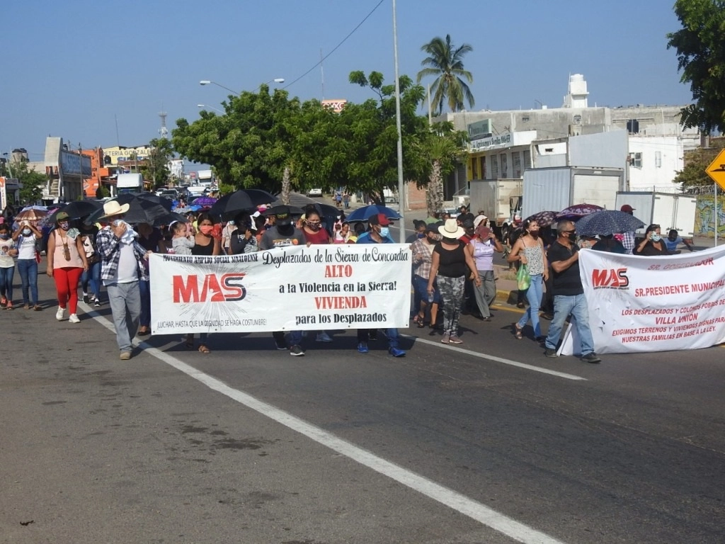 Personas desplazadas por la violencia en el sur de Sinaloa, que ahora radican en zona rural de la capital, marcharon en la carretera internacional en el tramo de Villa Unión-Durango para exigir apoyos. Foto Irene Sánchez