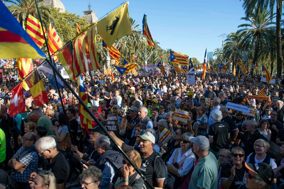 Personas sostienen banderas independentistas catalanas de Estelada durante la marcha en Barcelona el 1 de octubre de 2022. Foto Afp
 