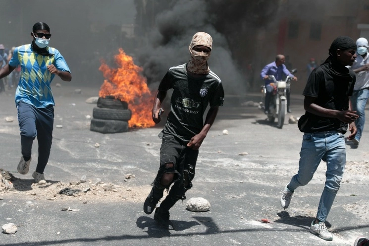 Los manifestantes corren para protegerse de los gases lacrimógenos lanzados por la policía haitiana durante una protesta contra la inseguridad realizada en Puerto Príncipe, Haití, el 7 de agosto de 2023. foto Ap 