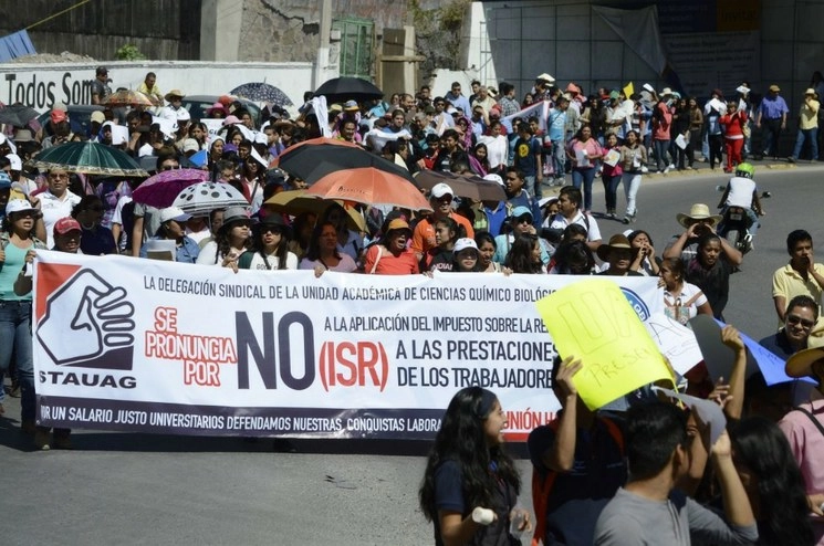 Integrantes del Sindicato de Trabajadores Académicos de la Universidad Autónoma de Guerrero (STAUAG) durante una manifestación en contra de la aplicación del cobro de ISR a las prestaciones, el 11 de febrero de 2016. Foto Cuartoscuro / Archivo