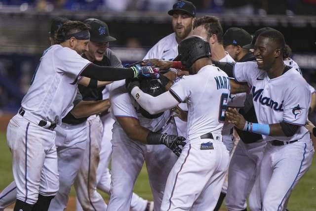 Beisbolistas de los Marlins de Miami festejan una anotación durante el juego. Foto Afp