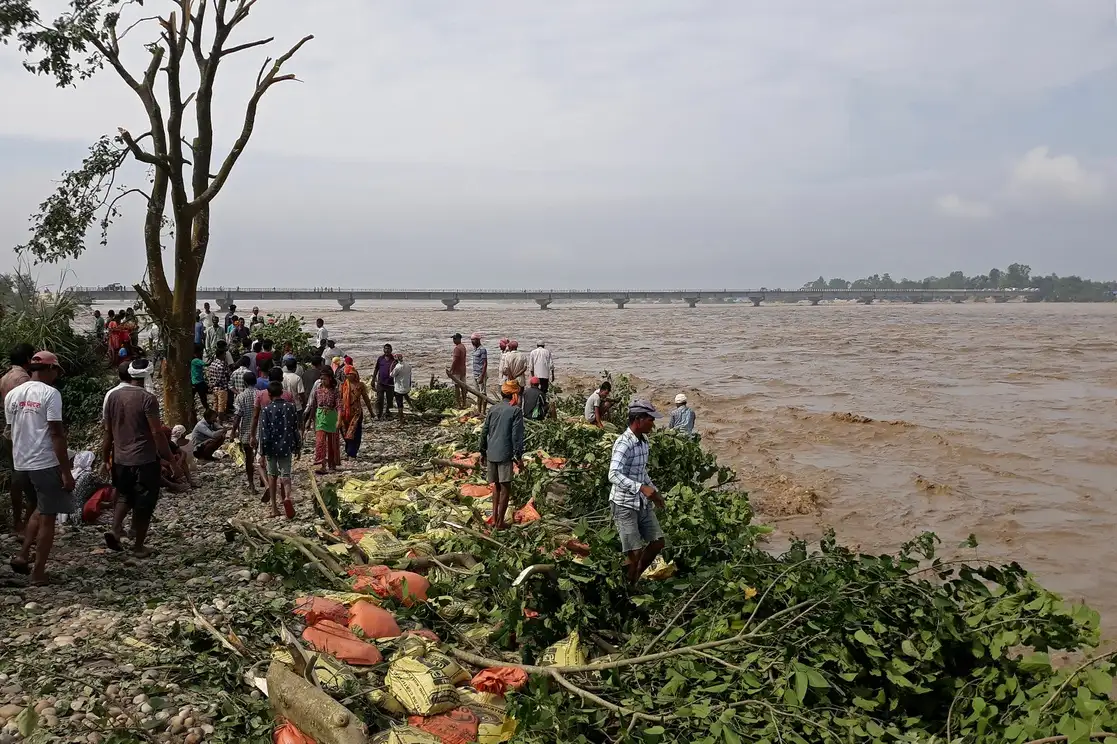 Un grupo de personas observa la crecida del río Karnali después de las fuertes lluvias en la aldea de Rajapur del distrito de Bardiya, Nepal, el 20 de octubre de 2021. Foto Afp