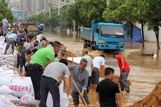 Habitantes de Jiujiang construyen barreras para frenar el agua, en China. Foto Afp 