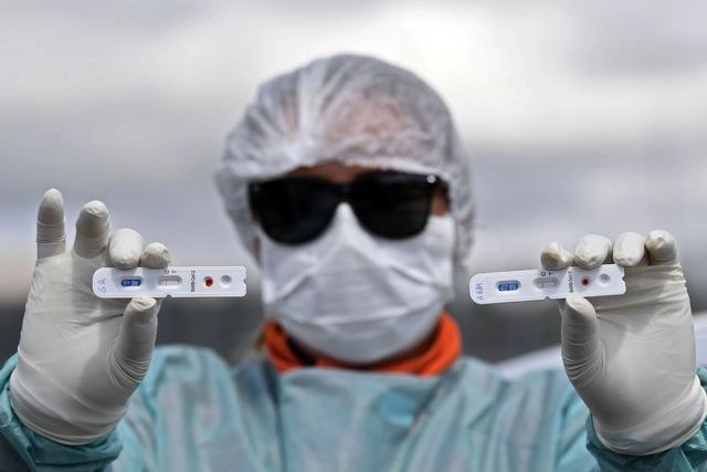 Un trabajador de la salud muestra resultados negativos de pruebas de coronavirus en Brasilia. Foto Afp 