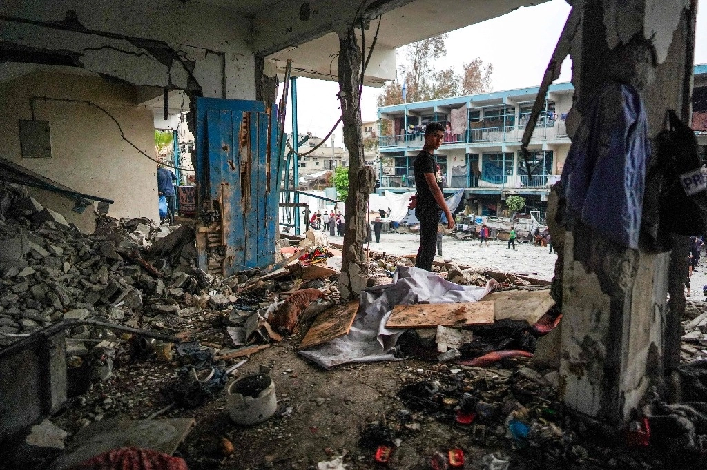 Un joven palestino se encuentra en una habitación destruida de una escuela de la ONU que alberga a personas desplazadas y que fue alcanzada durante el bombardeo israelí en Nuseirat, en el centro de la Franja de Gaza, el 6 de junio de 2024. Foto Afp