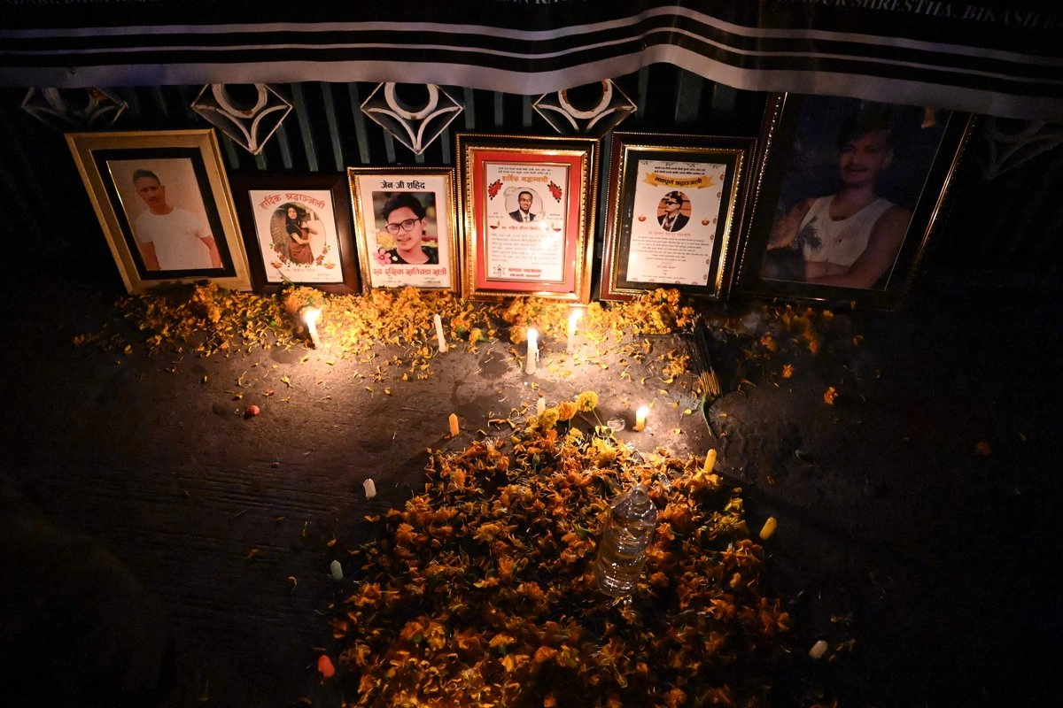 Retratos de las víctimas de las protestas anticorrupción de septiembre se exhiben durante una vigilia con velas frente al edificio del Parlamento, dañado por el fuego, en Katmandú, el 9 de noviembre de 2025, al cumplirse dos meses de la manifestación liderada por jóvenes que derrocó al gobierno. Foto 