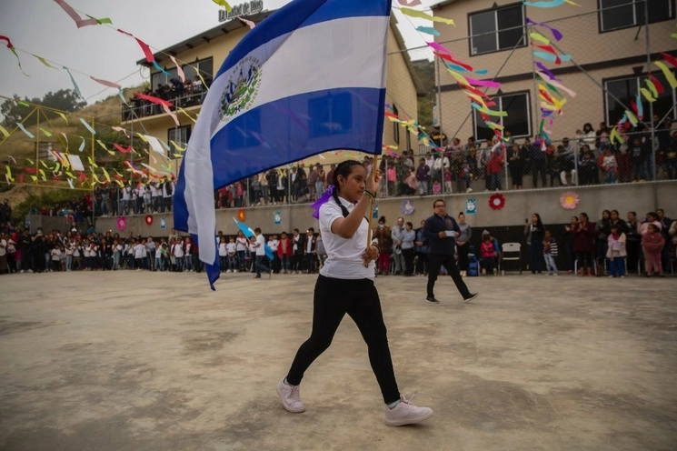 En la ceremonia del Día del Niño... migrante, en la cancha de la escuela Embajadores de Jesús, en Tijuana, ondean banderas de varios países, además de la mexicana. El plantel opera bajo la tutela del Conafe y educa a 656 alumnos desplazados. Foto Omar Martínez 