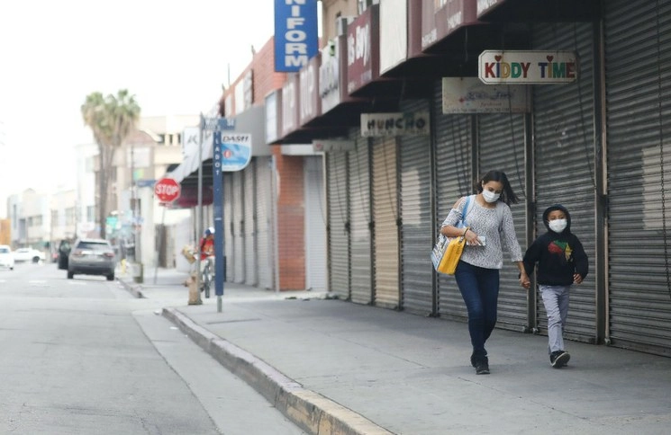 Dos personas caminan por las calles de Los Angeles. Foto Afp