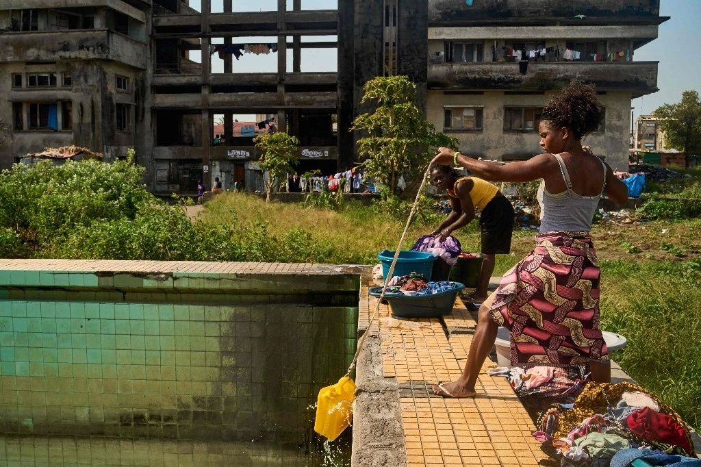 Una mujer utiliza una cuerda y un recipiente de plástico para sacar agua de la piscina olímpica para lavar la ropa en el Grande Hotel de Beira, Mozambique, el 12 de octubre de 2024. Foto Afp